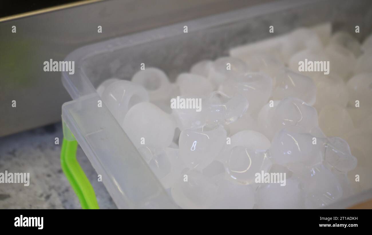 Many ice cubes for drinks in a container. Frozen water for cooling