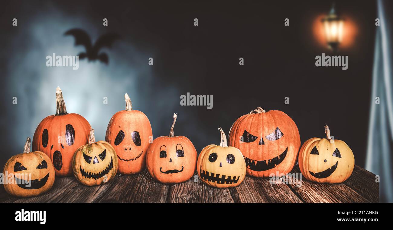 scary funny Halloween pumpkins on wooden table Stock Photo