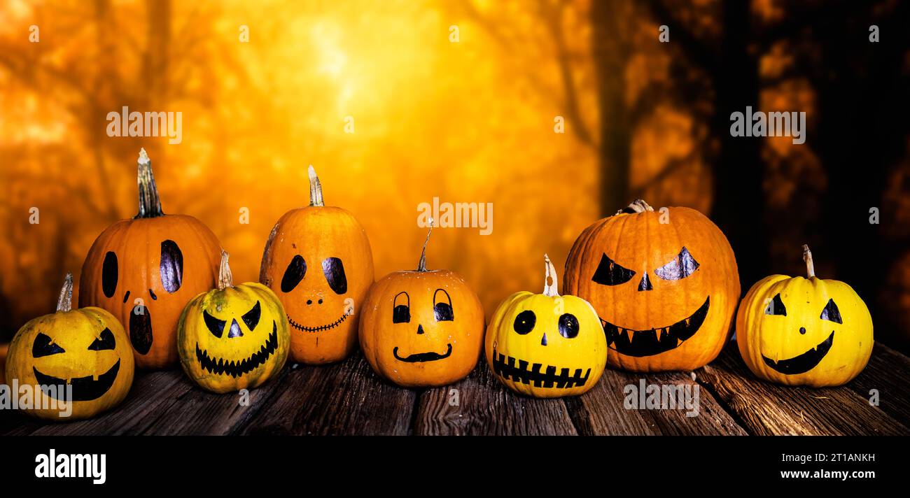 scary funny Halloween pumpkins on wooden table Stock Photo