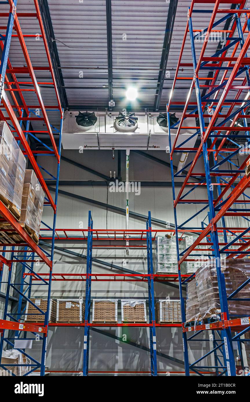 https://c8.alamy.com/comp/2T1B0CR/a-three-fan-industrial-refrigeration-evaporator-in-the-freezer-at-an-ammonia-cycle-cold-storage-warehouse-red-and-blue-shelving-shown-2T1B0CR.jpg