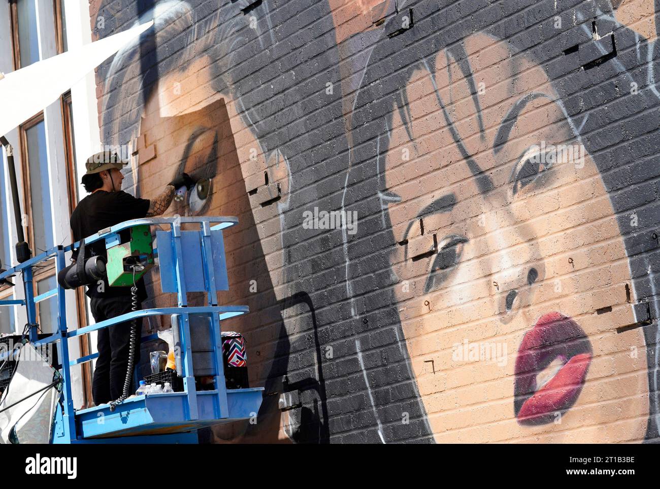 Artist Royyal Dog of Los Angeles works on his mural of famous female