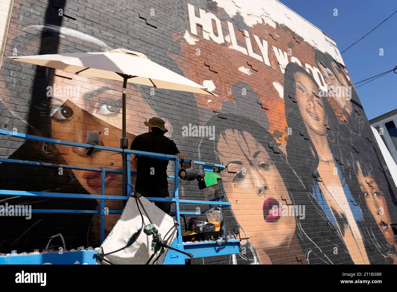 Artist Royyal Dog of Los Angeles works on his mural of famous female