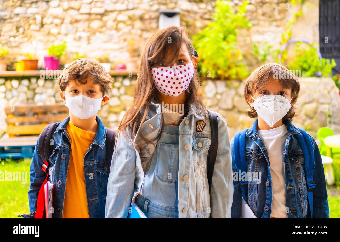Three brother children with face masks ready for going back to school ...