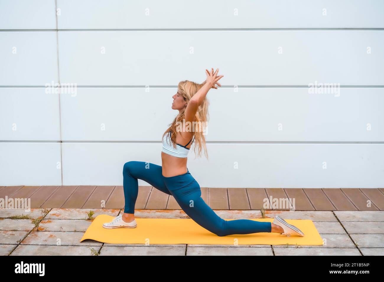 Young Fit Woman Doing a Yoga Pose Standing with One Leg Raised Up