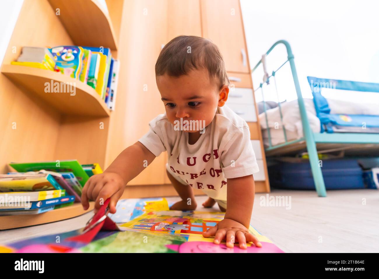 Young Caucasian mother playing with her in the room with toys. Baby less than a year learning the first lessons of her mother. Boy playing on the Stock Photo