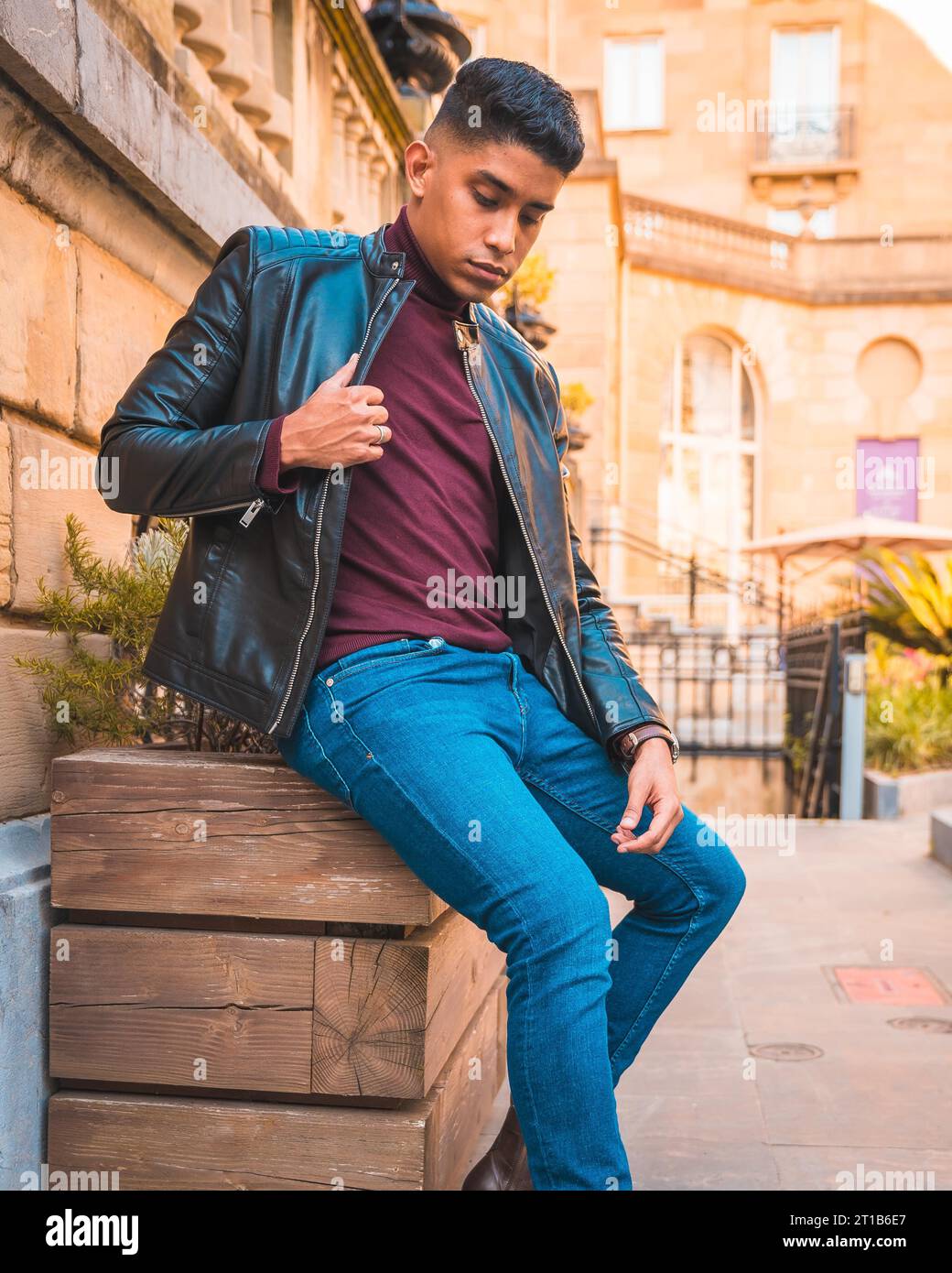 Trendy lifestyle of a Latino guy in the city. Jeans, leather jacket and brown shoes Stock Photo