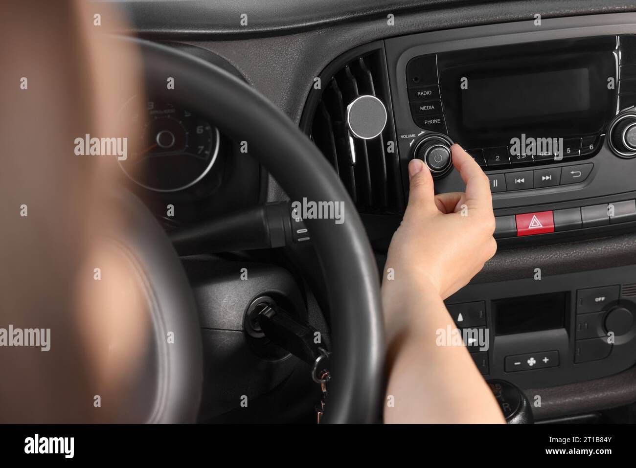 Woman Turning Up The Volume On The Car Radio Stock Photo