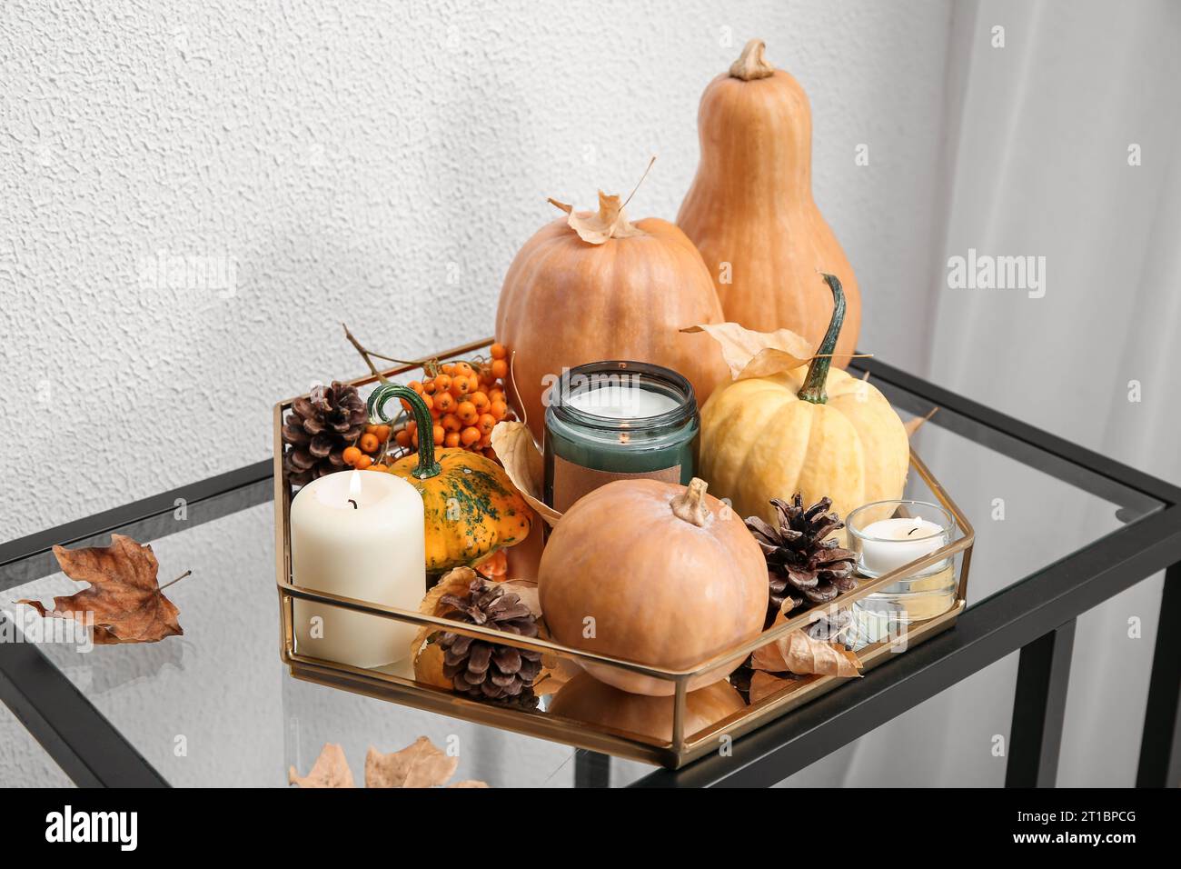 Tray with burning candles, pine cones, pumpkins and autumn leaves on ...