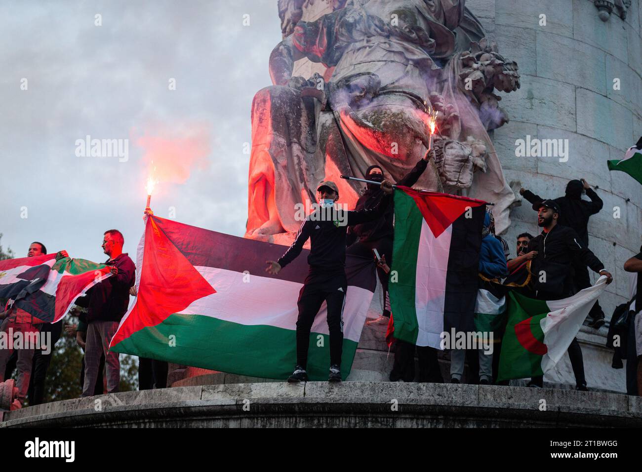 Paris, France. 12th Oct, 2023. Pro-Palestinian demonstrators hold flags ...