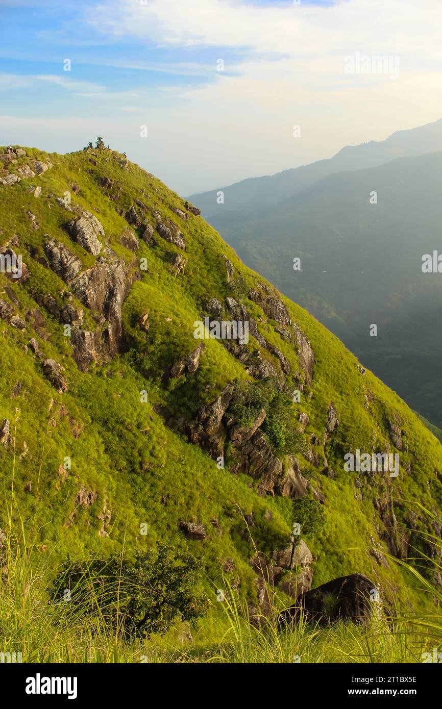Golden light above the lush green hills of the Little Adam's peak, Ella, Sri Lanka. Vertical image with copy space for text Stock Photo