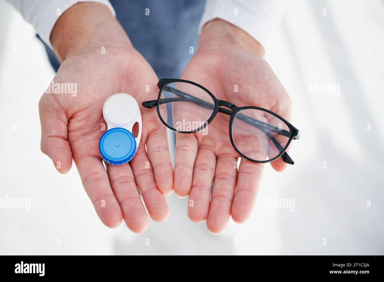Eye care, hands of doctor with glasses and contact lens in case for ...