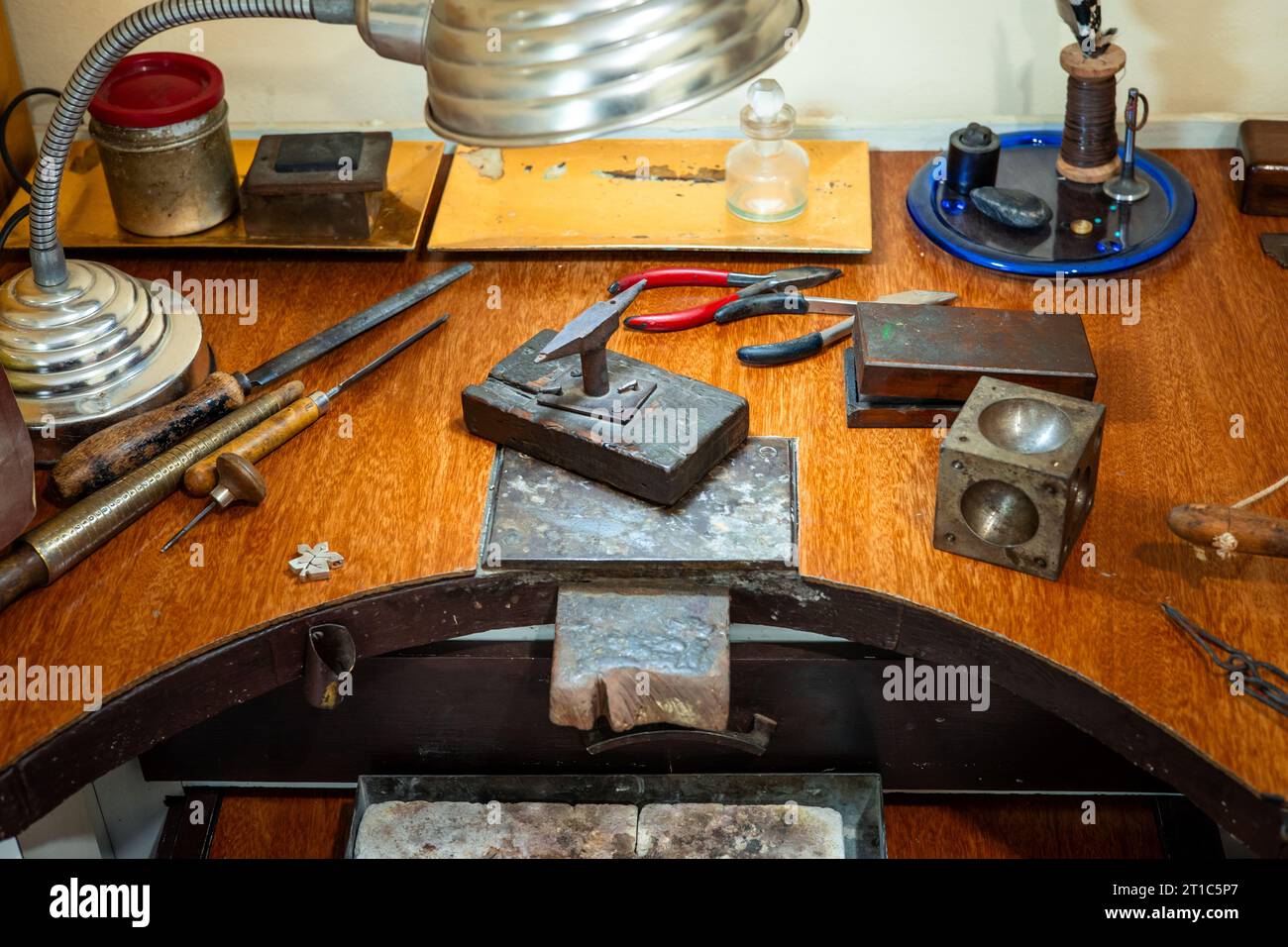 Craft workplace of a jeweler. Jewelry tools and equipment on a goldsmith wooden desk table. Stock Photo