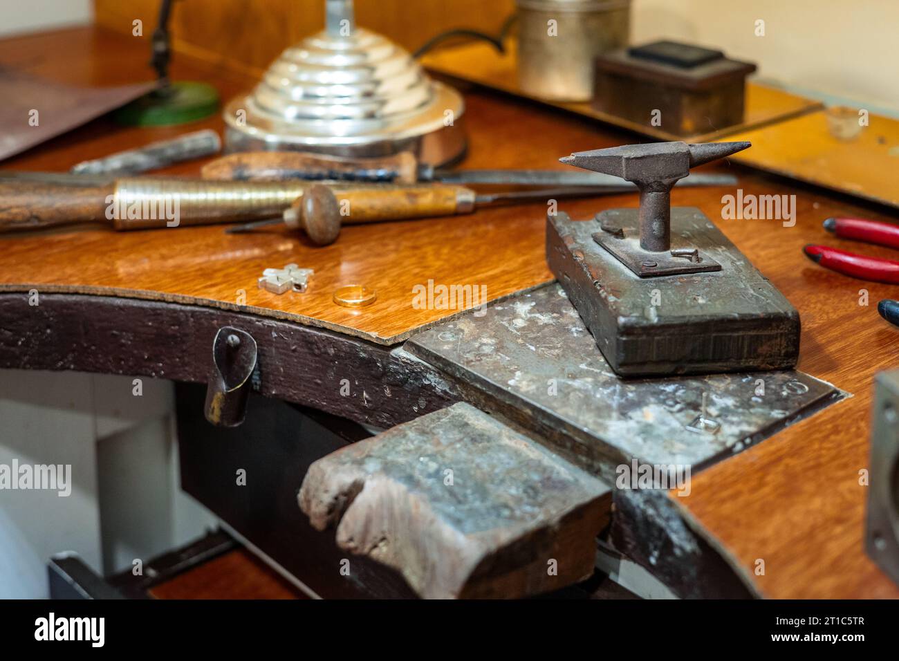 Craft workplace of a jeweler. Jewelry tools and equipment on a goldsmith wooden desk table. Stock Photo