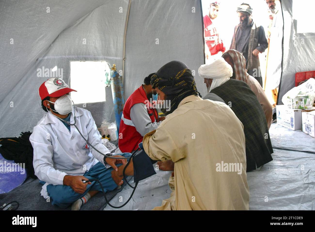 An Afghan Red Crescent Society doctor gives medical assistance to a ...