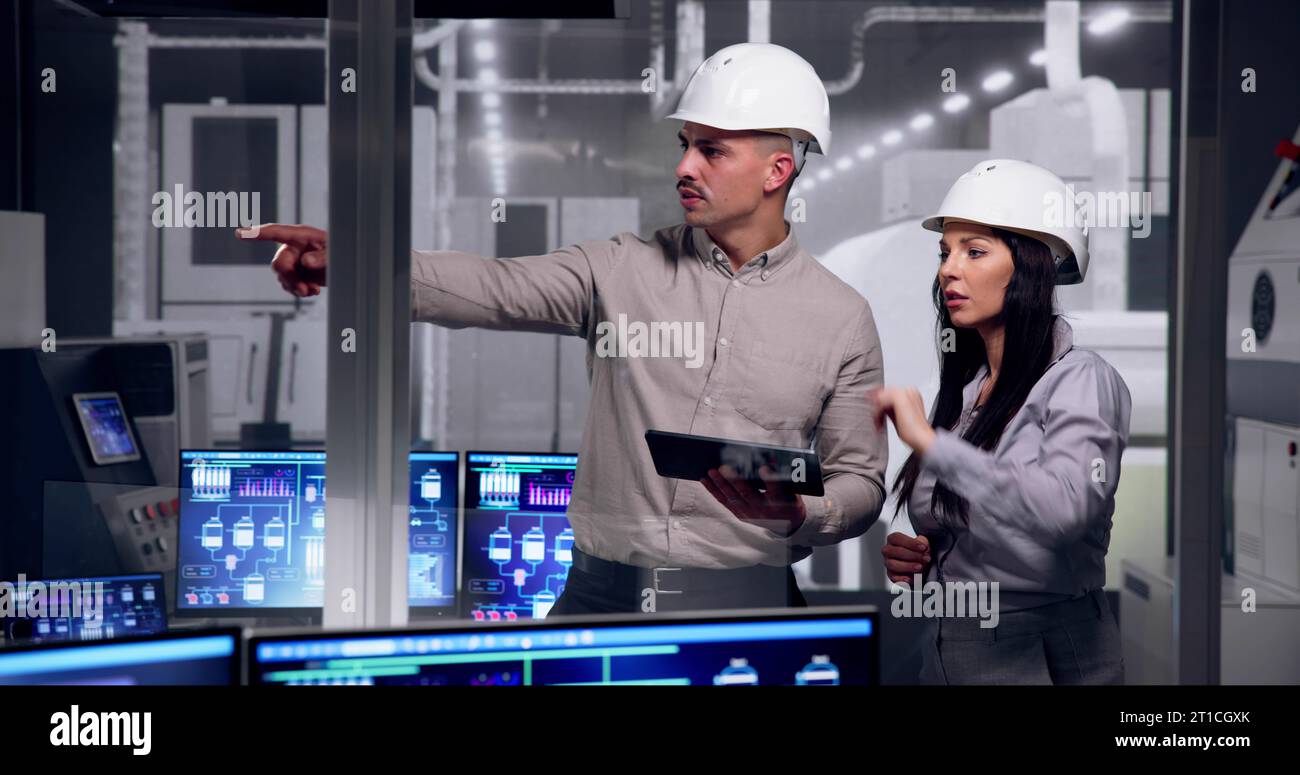 Factory Engineers In Helmets. Checking Industrial Facility Stock Photo