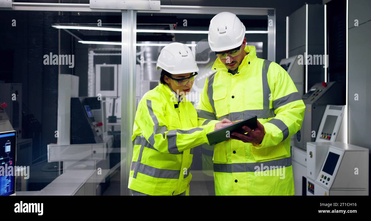 Factory Engineers In Helmets. Checking Industrial Facility Stock Photo