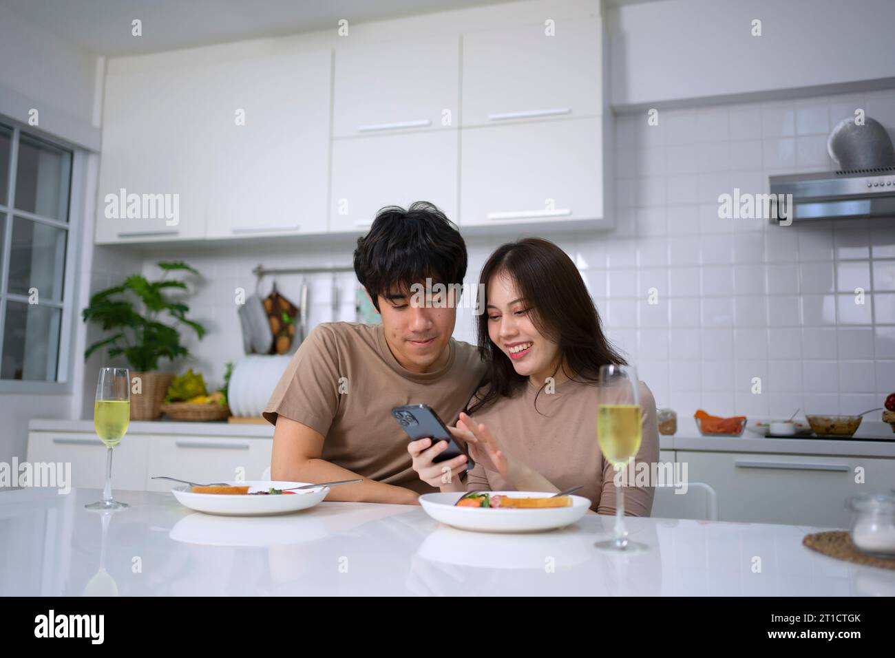 Young couple is shopping online in kitchen. Lifestyle and leisure activity concept. Stock Photo