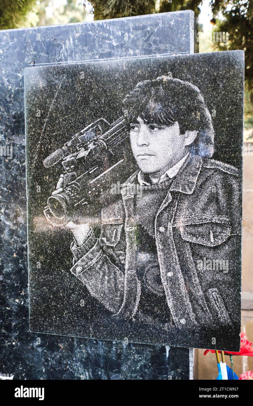 A black granite grave marker with an etched picture of a dead fighter ...