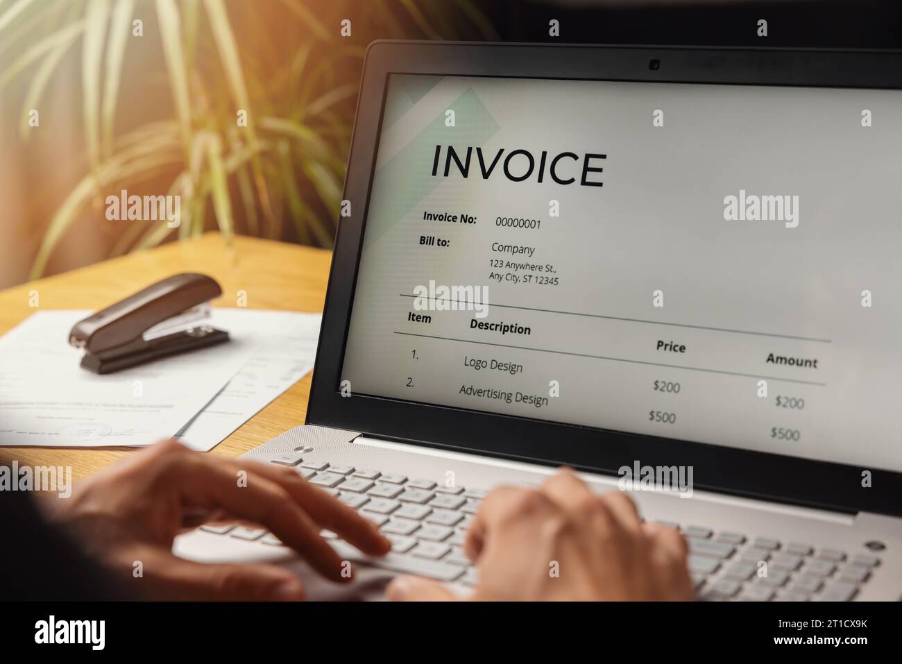 freelancer make an invoice on laptop computer at home office. business accounting Stock Photo