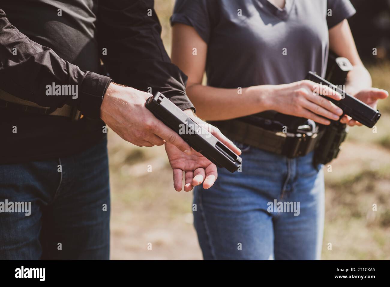A woman learns to shoot a pistol at a shooting range with an instructor
