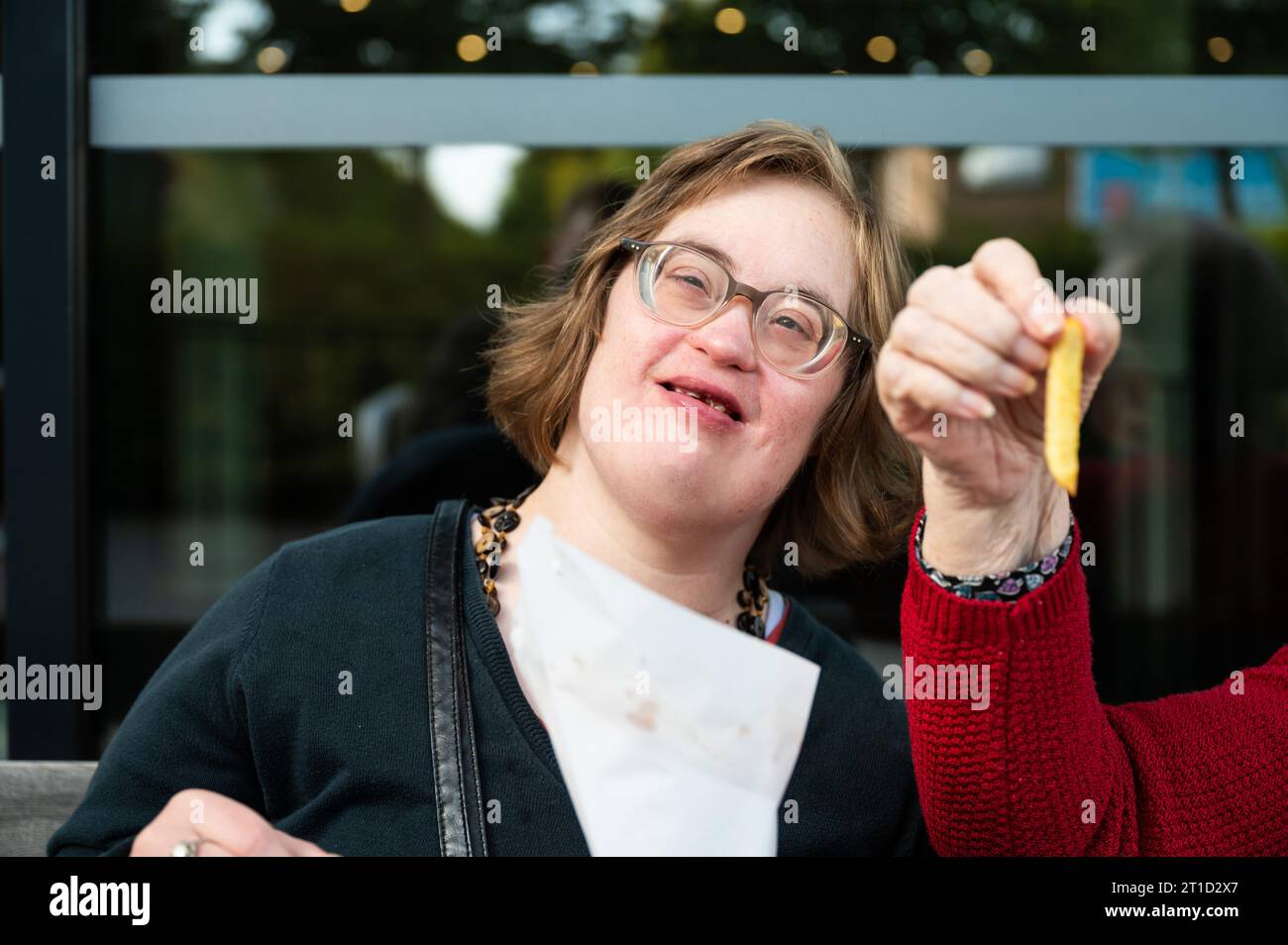 Woman with Down Syndrome eating French Fries with her 85 yo mother, Tienen, Flanders, Belgium Stock Photo