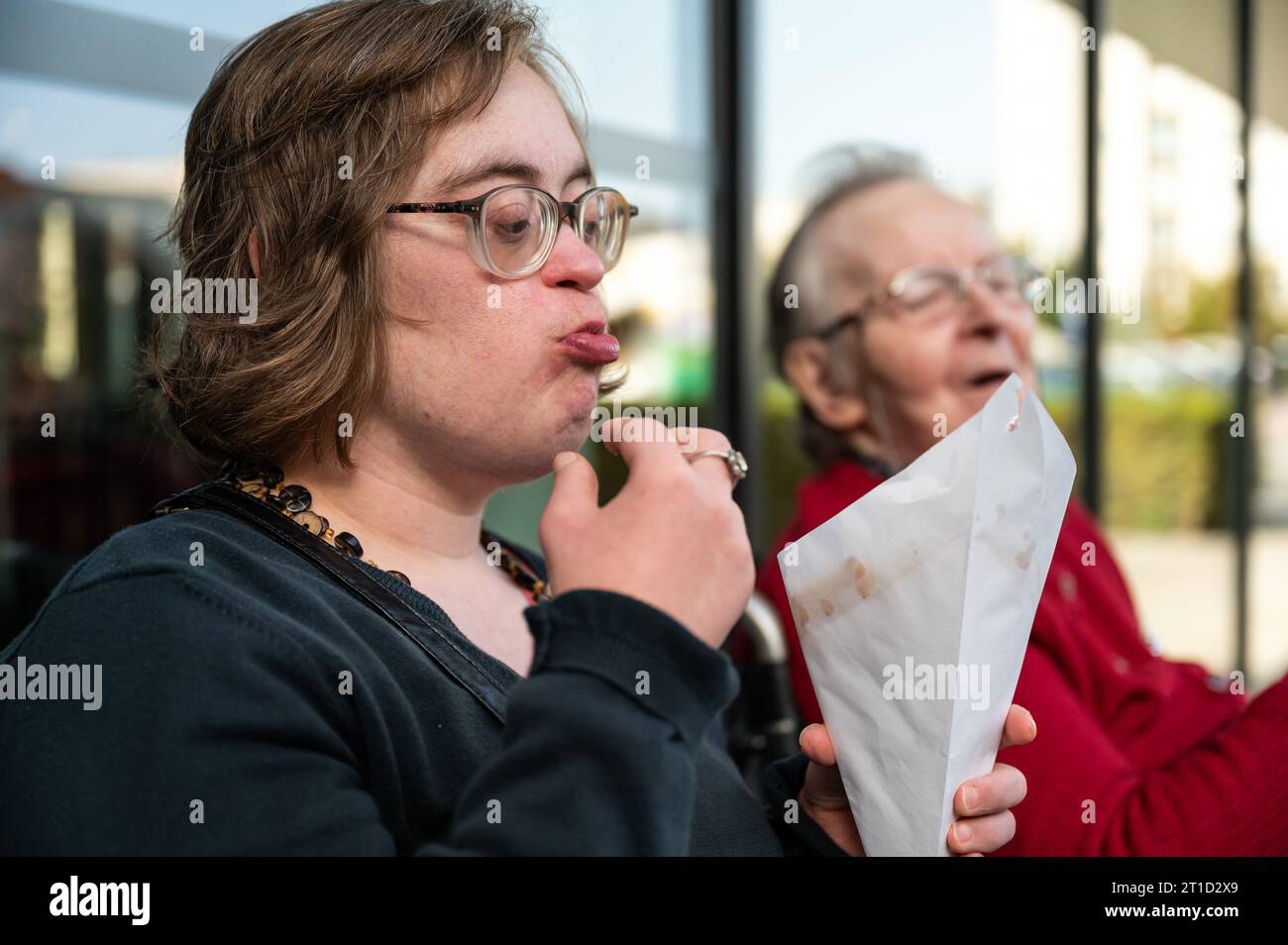 Woman with Down Syndrome eating French Fries with her 85 yo mother, Tienen, Flanders, Belgium Stock Photo