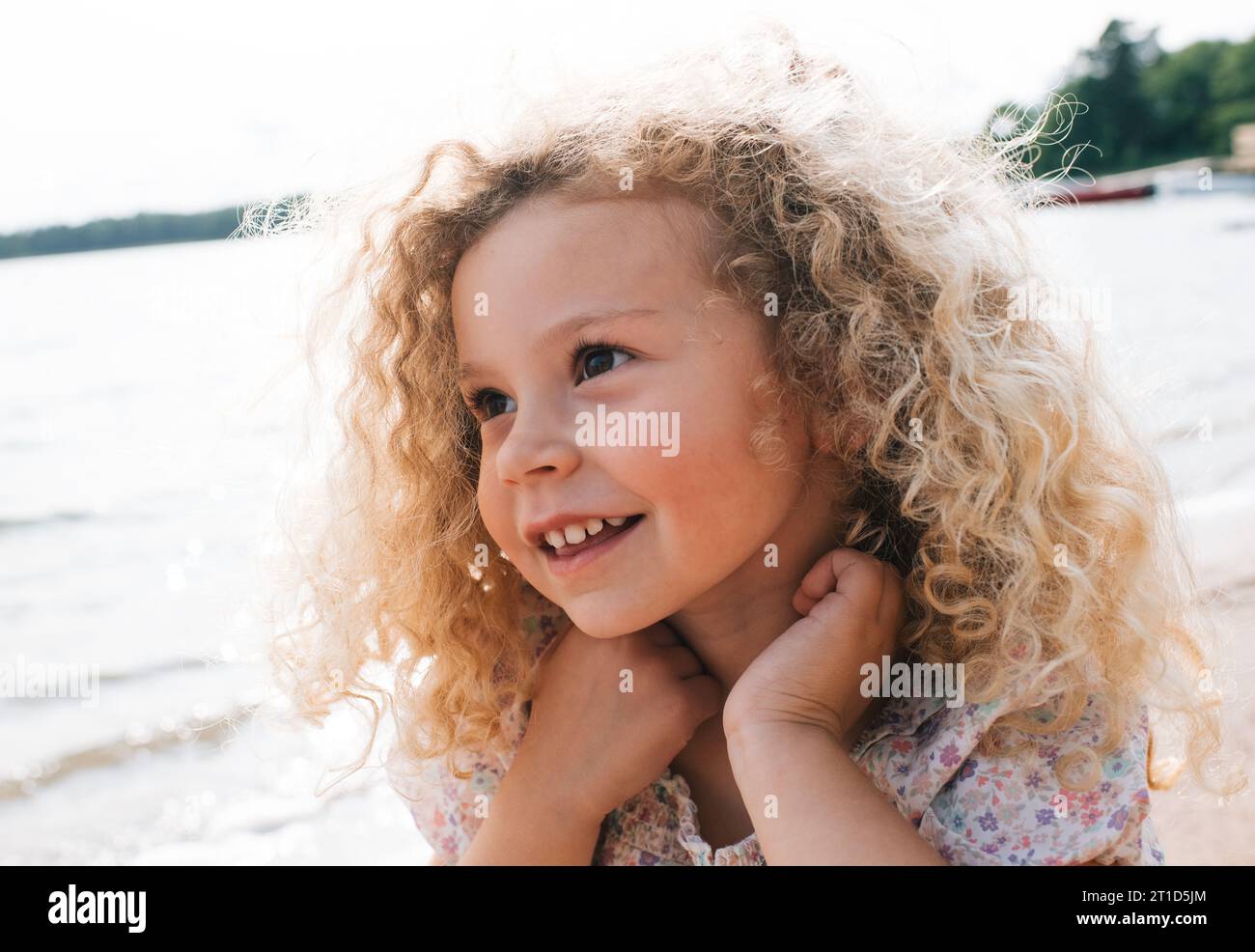 portrait of a beautiful child smiling with blonde curly hair Stock