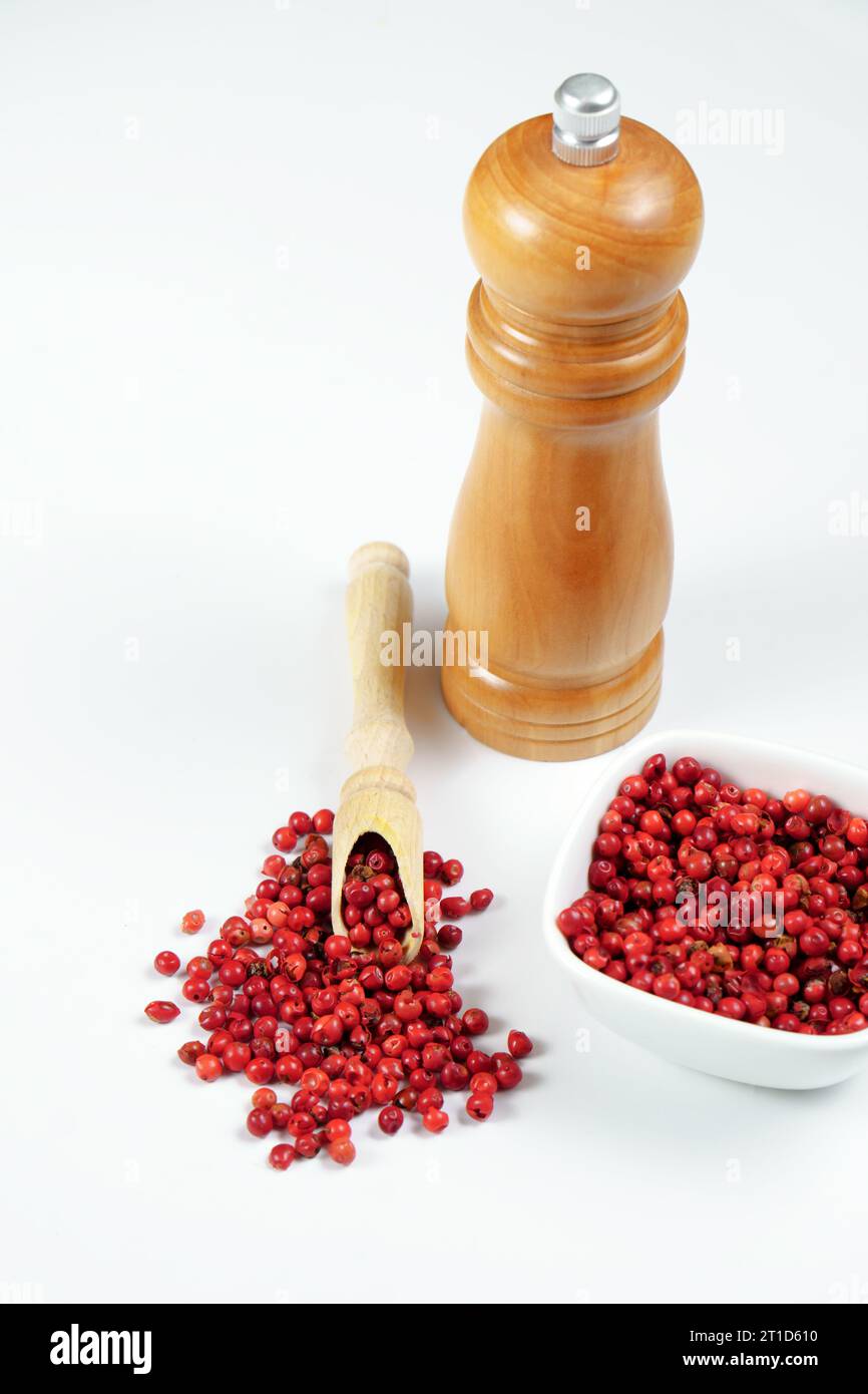 https://c8.alamy.com/comp/2T1D610/pink-peppercorns-in-a-wooden-spoon-with-a-wooden-pepper-shaker-2T1D610.jpg