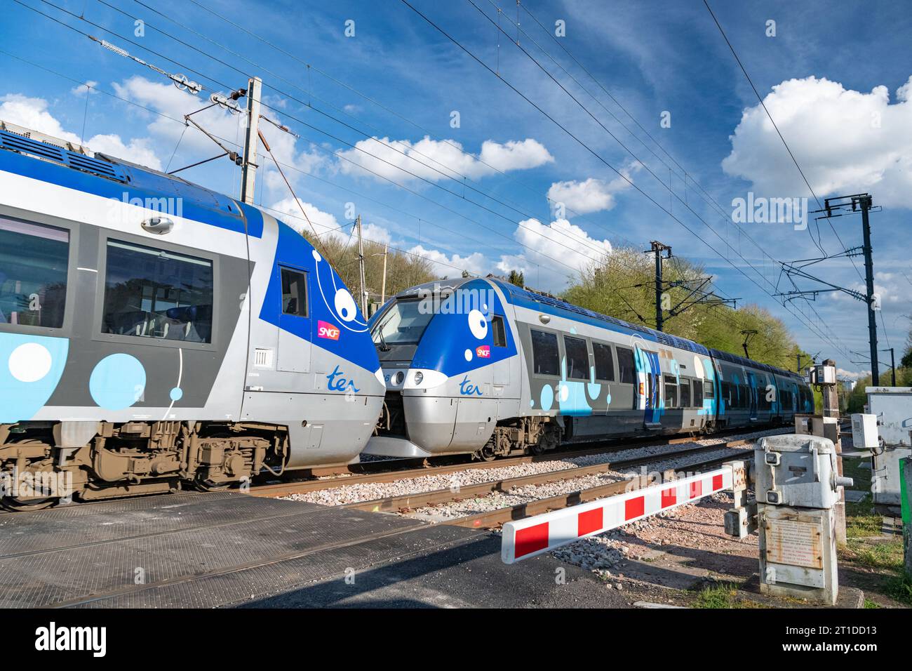 TER local train passing through a level crossing, railway linking Paris, Rouen and Le Havre, in Normandy, Le Houlme. Stock Photo