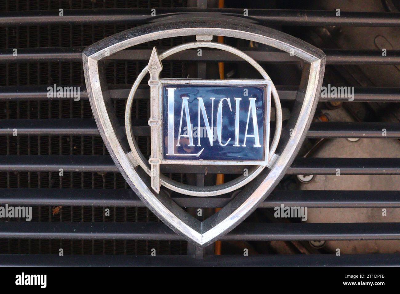 Lancia radiator grille shield badge affixed to a 1973 Fulvia coupe 3 fitted with a 1298cc V4 engine and 1.3S badges, displayed at an Italian car show. Stock Photo