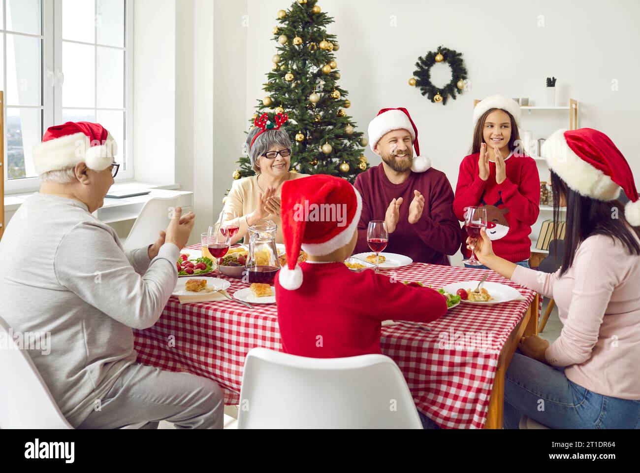 Joyful family sitting around table, eating Christmas dinner and having