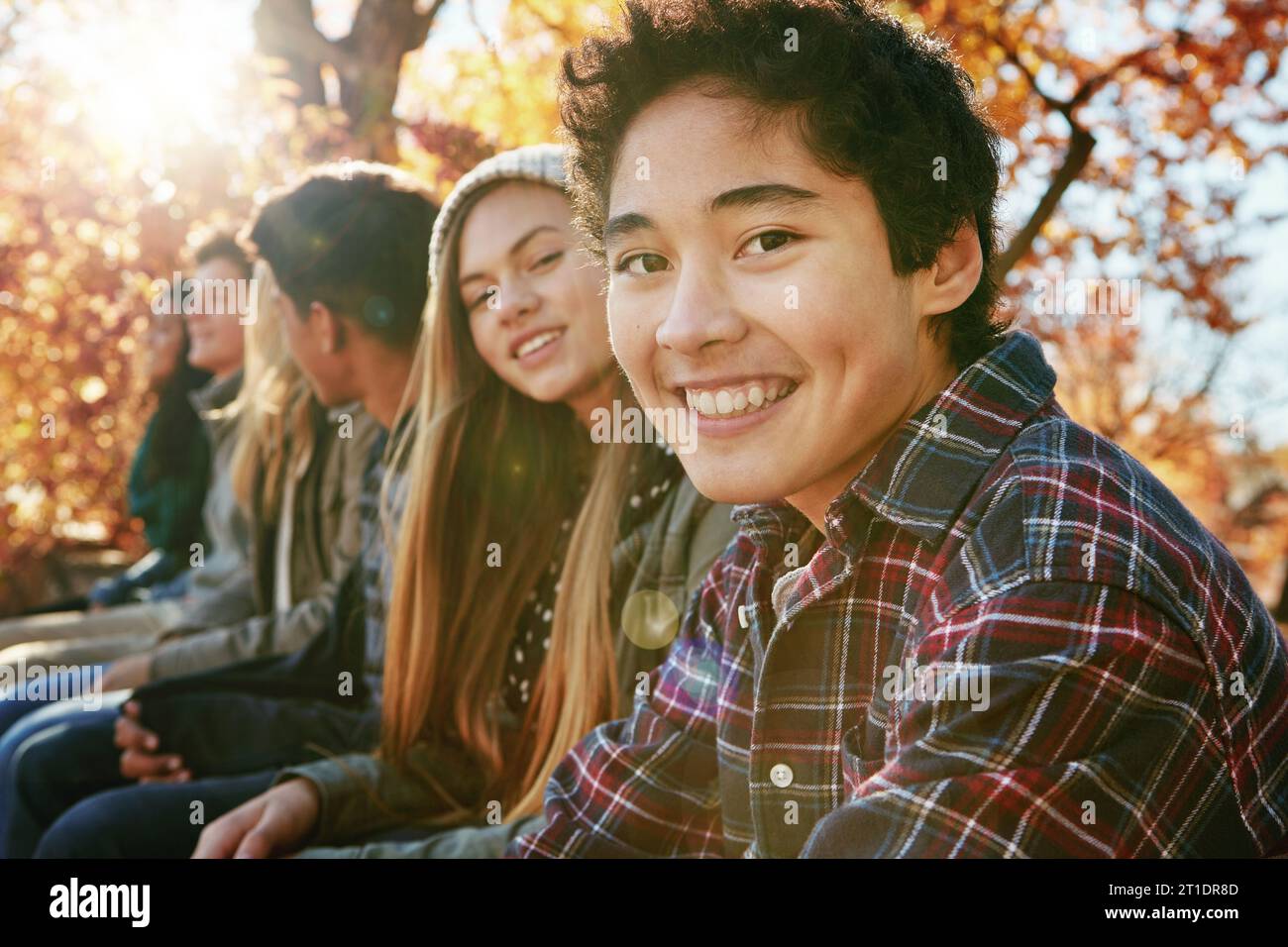 Teenager, group and portrait in park, boy and together on holiday, nature and relax by trees. Youth culture, happy friends and gen z school kids in Stock Photo