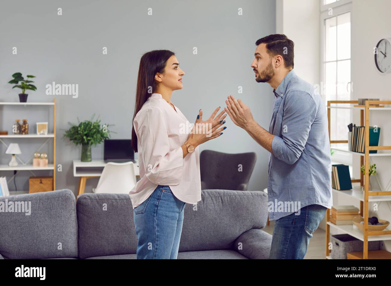 Stressed young family couple having disagreement and arguing in living room Stock Photo