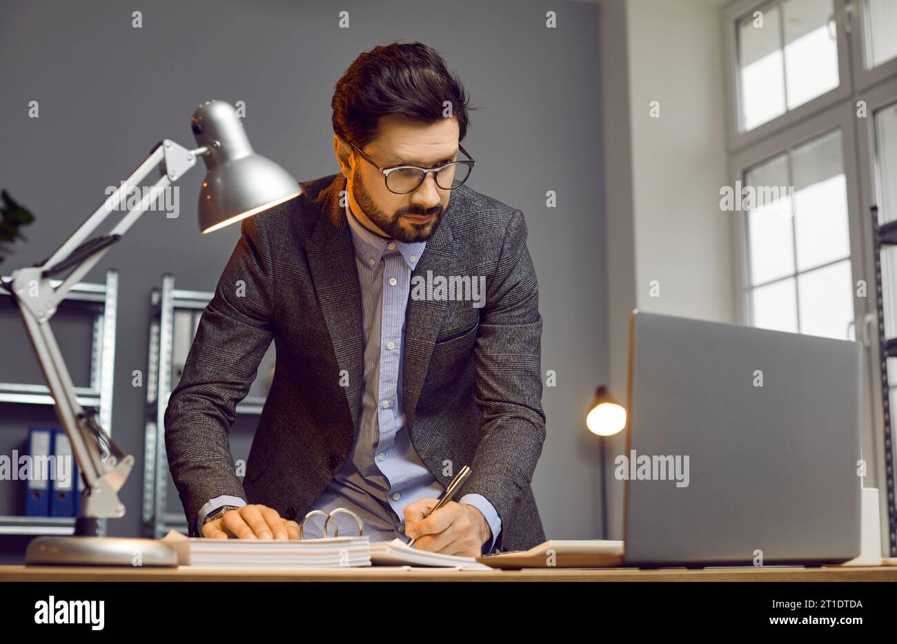 Handsome busy businessman working on some project in modern office Stock Photo