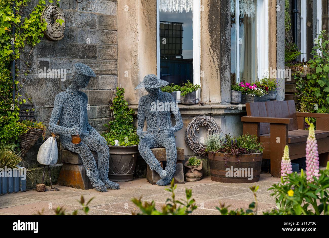 Quirky wire mesh sculpture figures sitting in a front garden, Portobello, Edinburgh, Scotland, UK Stock Photo