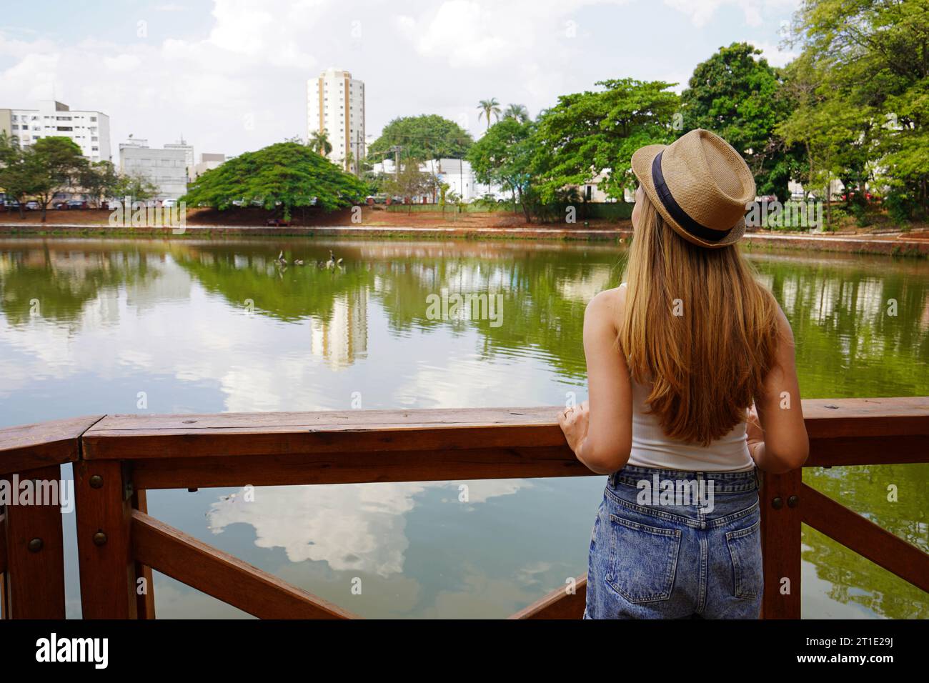 Visiting Goias State in Brazil. Back view of young traveler woman in the urban park Bosque dos buritis in Goiania, Goias, Brazil. Stock Photo
