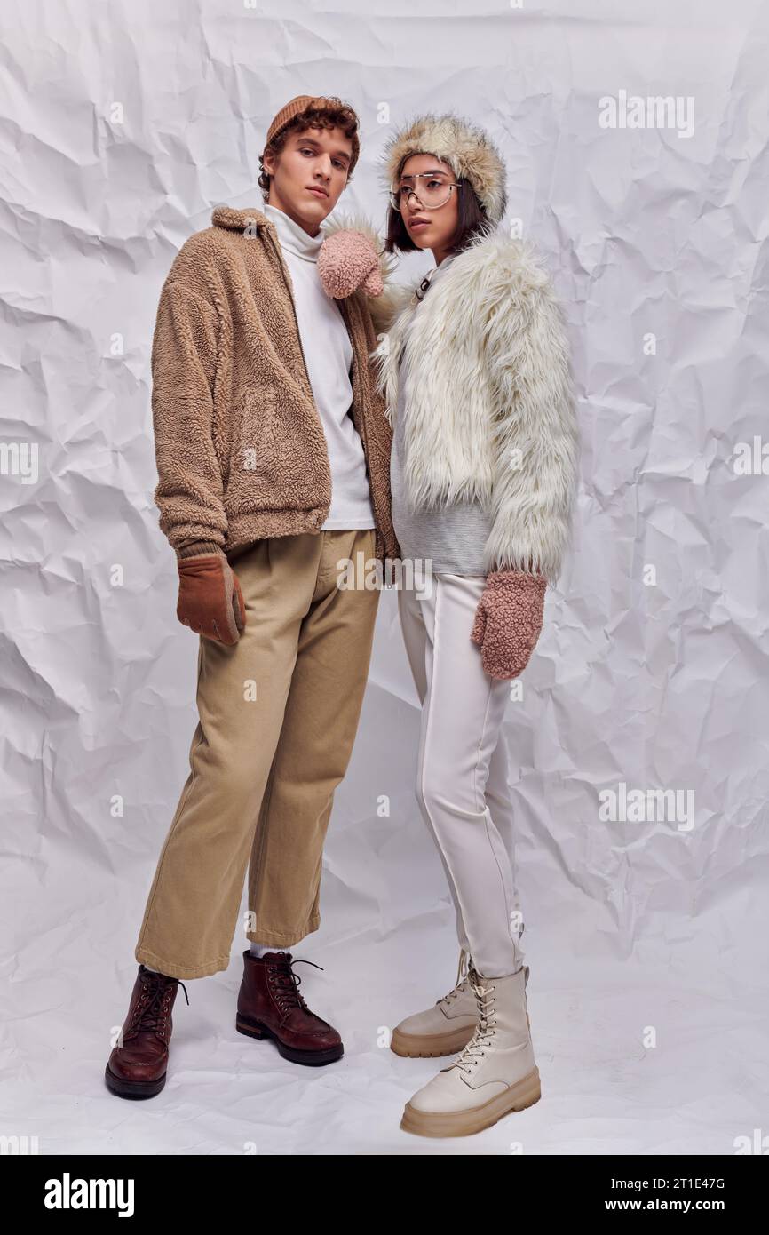 asian woman in faux fur jacket and hat leaning on shoulder of trendy ...