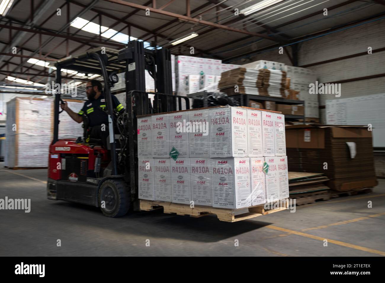 An operator moves a pallet of packaged refrigerant cylinders within a ...