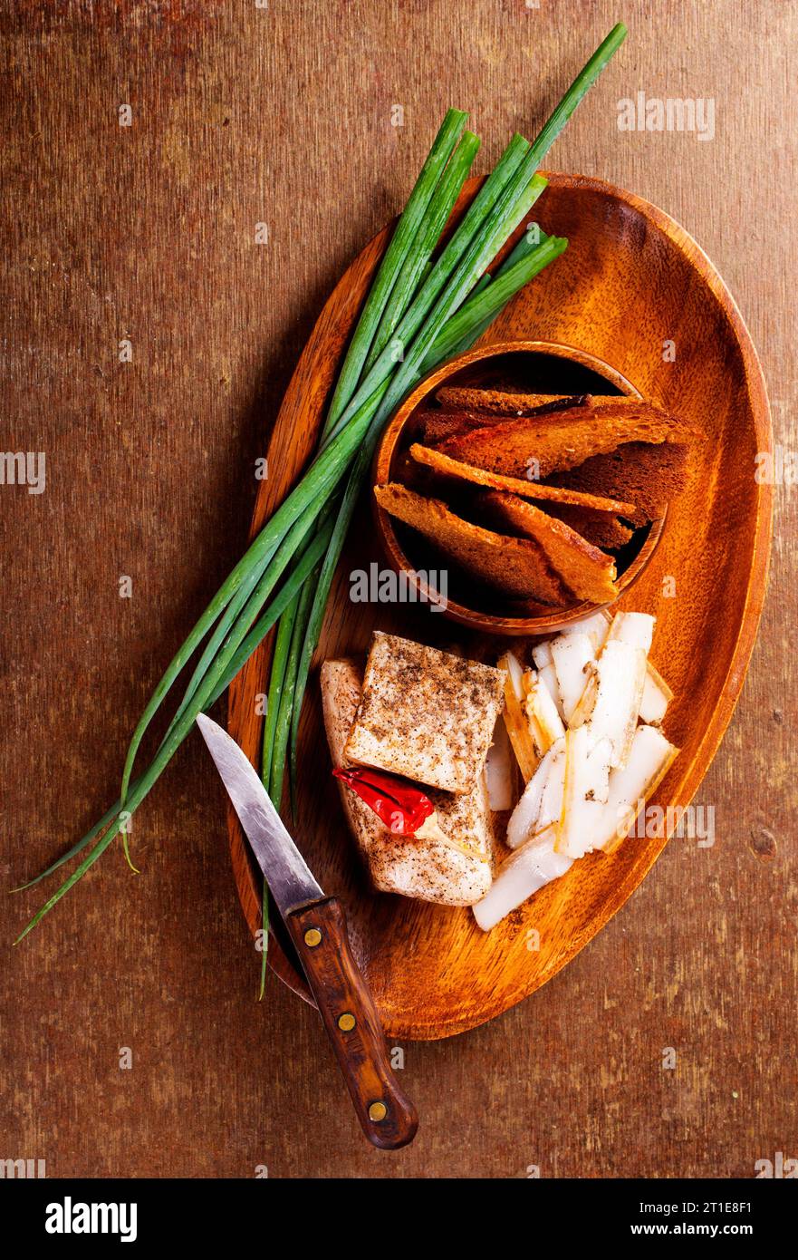 Pork fatback with spices, rye bread and green onion on wooden table Stock Photo