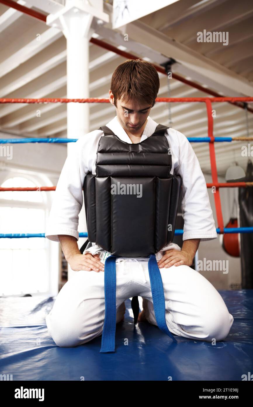 Karate, man and kneeling, exercise with fight in ring and martial arts