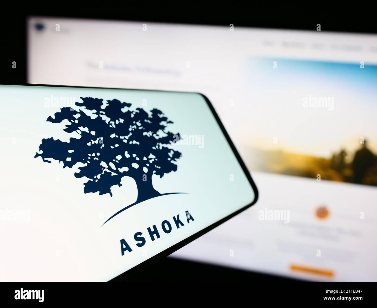 Smartphone with logo of social entrepreneurship organization Ashoka in front of website. Focus on center-left of phone display. Stock Photo
