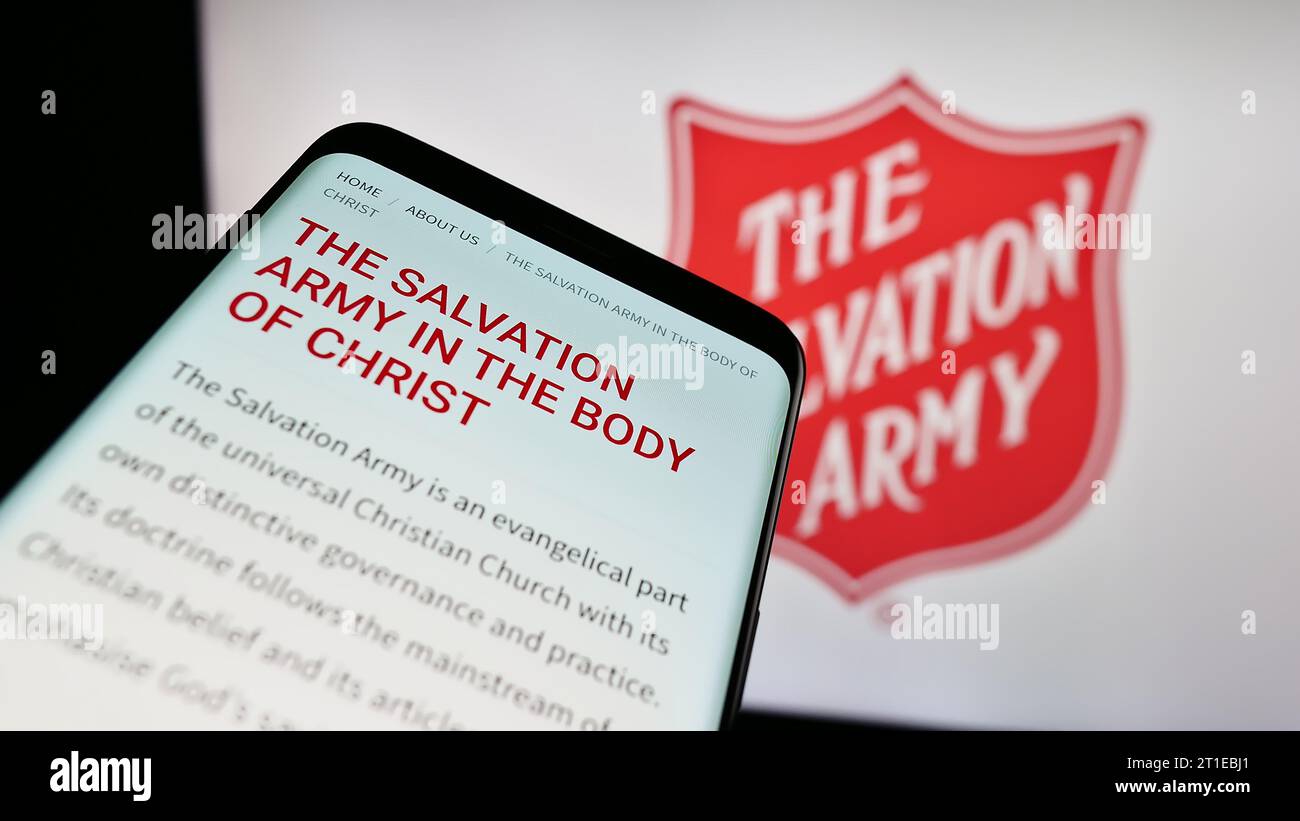 Mobile phone with webpage of Protestant charity organization The Salvation Army (TSA) in front of logo. Focus on top-left of phone display. Stock Photo