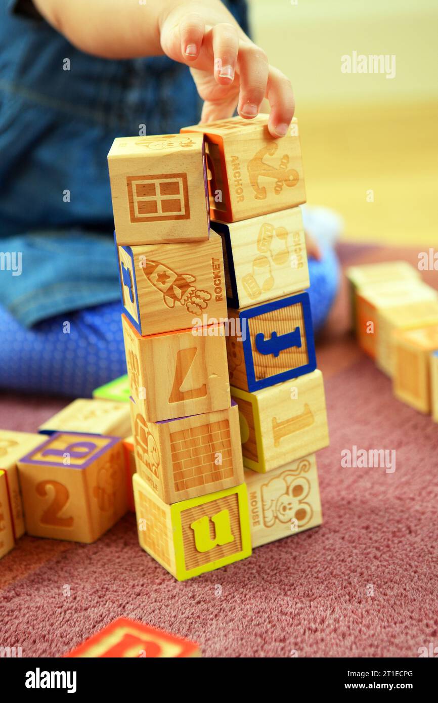Two year old girl playing and learning with building bricks Stock Photo