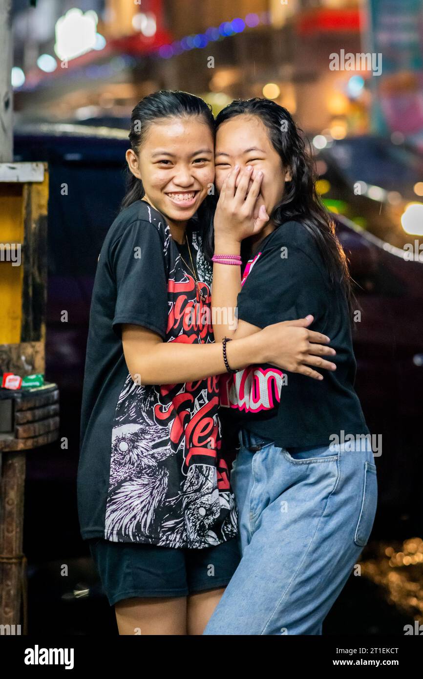 Two young pretty Filipino girls pose and smile for their portrait in the Tondo district of Metro Manila, The Philippines. Stock Photo