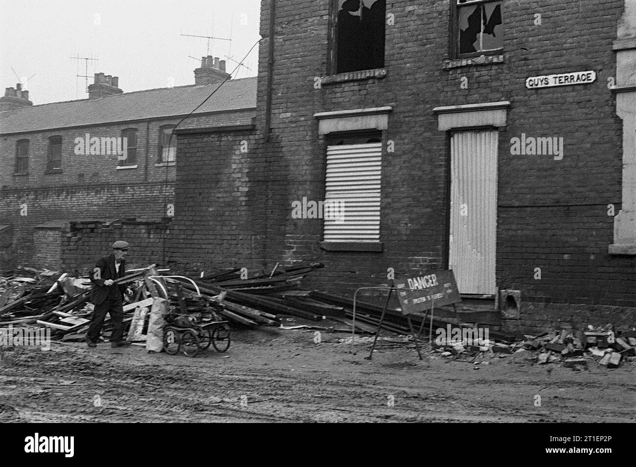 Elderly man collecting firewood in a pushchair from Guys Terrace