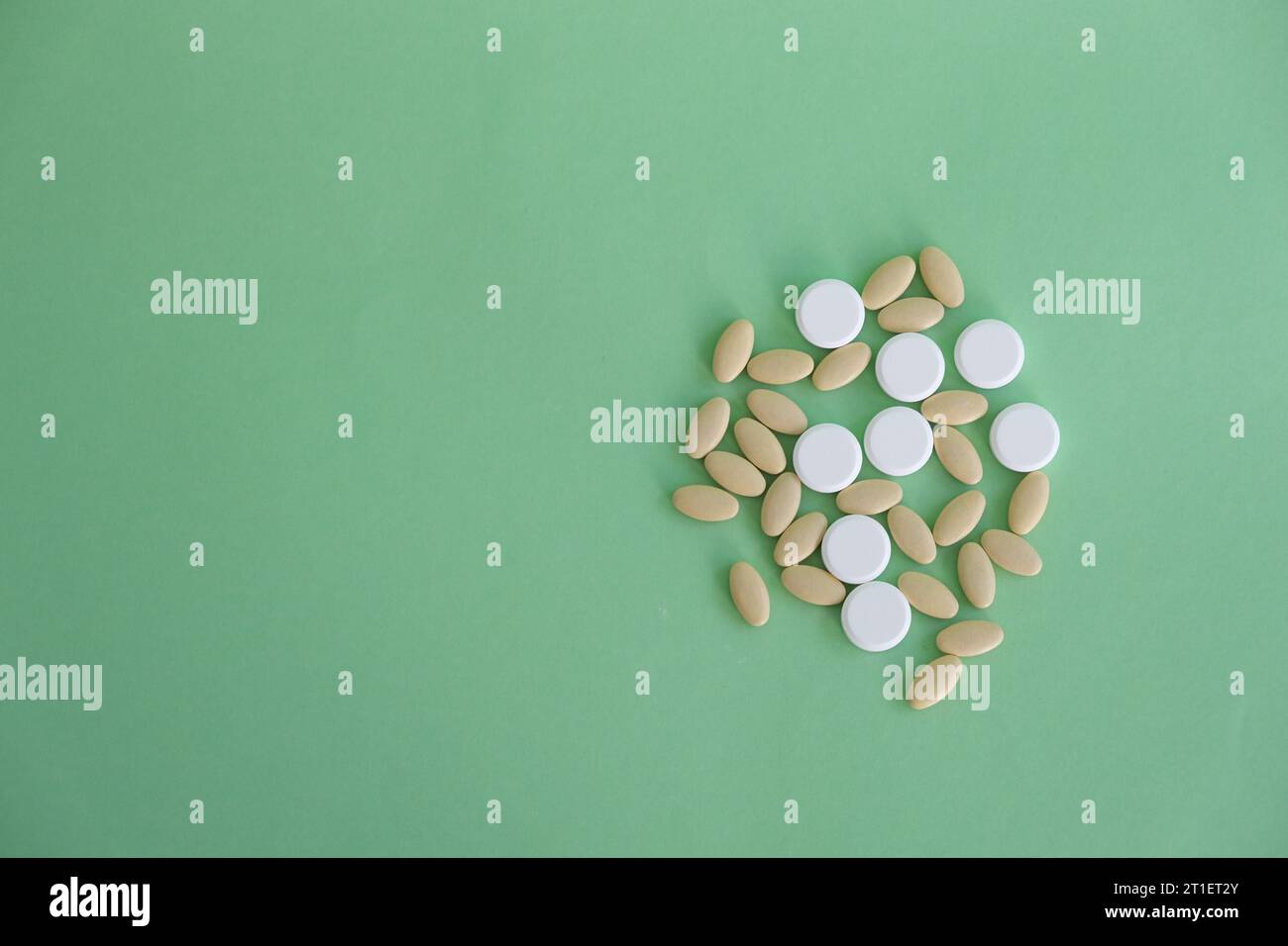 Close up top view heap of pills vitamin supplement on green background. Medical health care pharmacy concept background. Open space area. Stock Photo