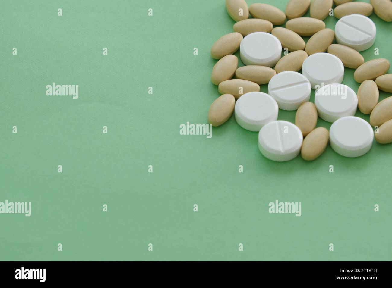 Close up top view heap of pills vitamin supplement on green background. Medical health care pharmacy concept background. Open space area. Stock Photo