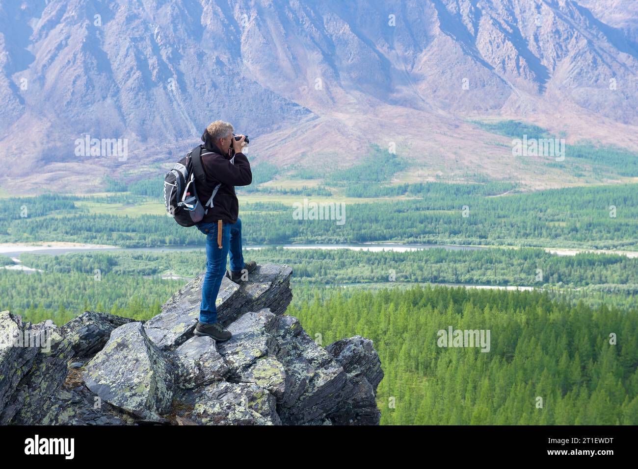YAMAL, RUSSIA - AUGUST 20, 2018: Photographer in the mountains of the polar Ural Stock Photo