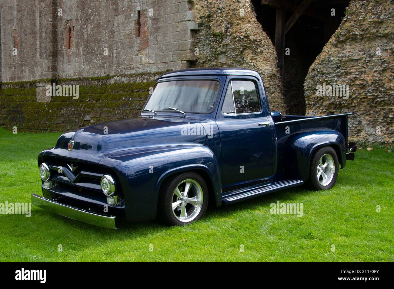 1950s American Ford Truck, parked on grassland near an ancient castle wall Stock Photo
