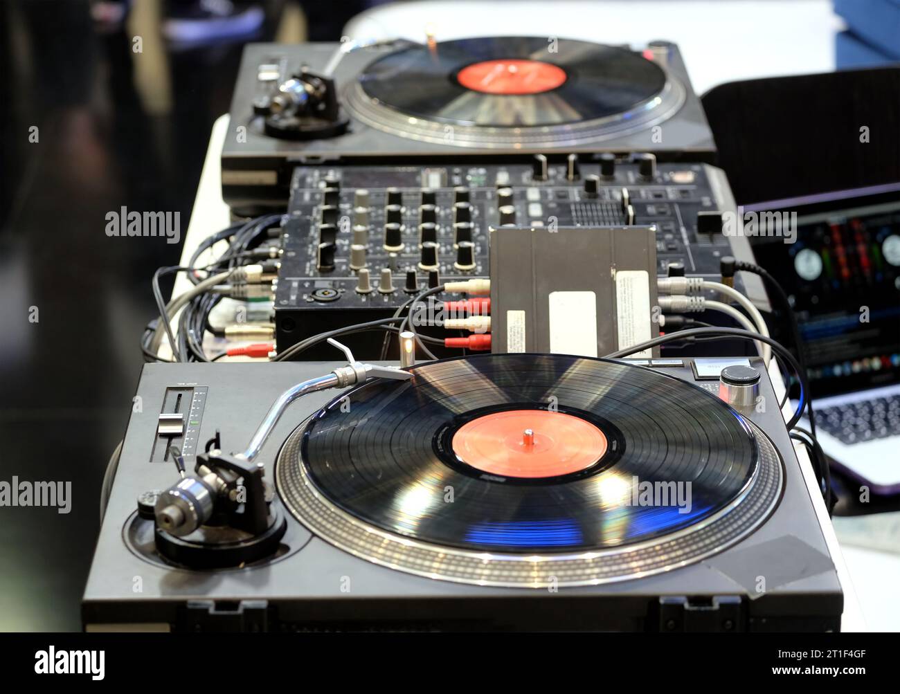 Modern DJ console with two vinyl players with records, mixers and